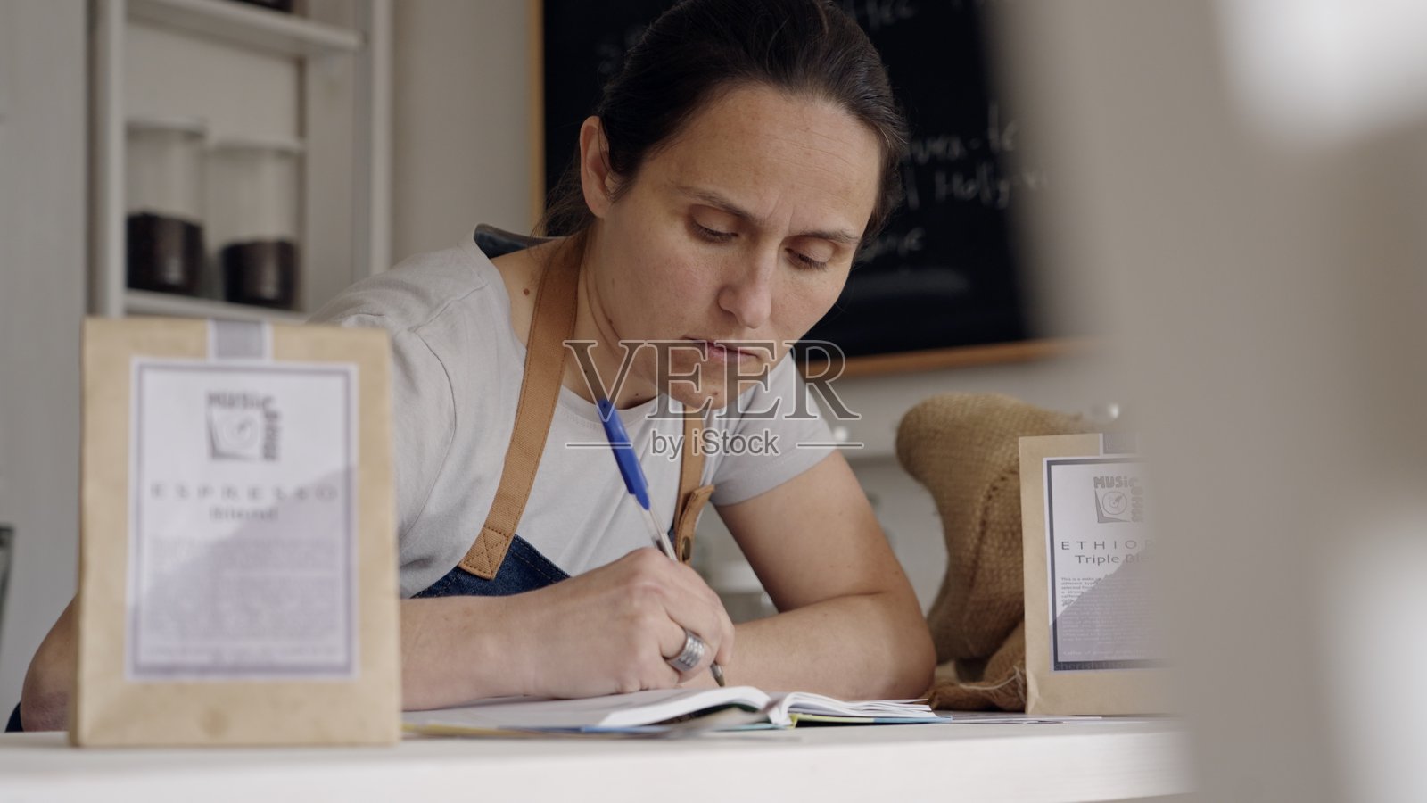 零废弃商店。特色咖啡店老板在做财务。照片摄影图片