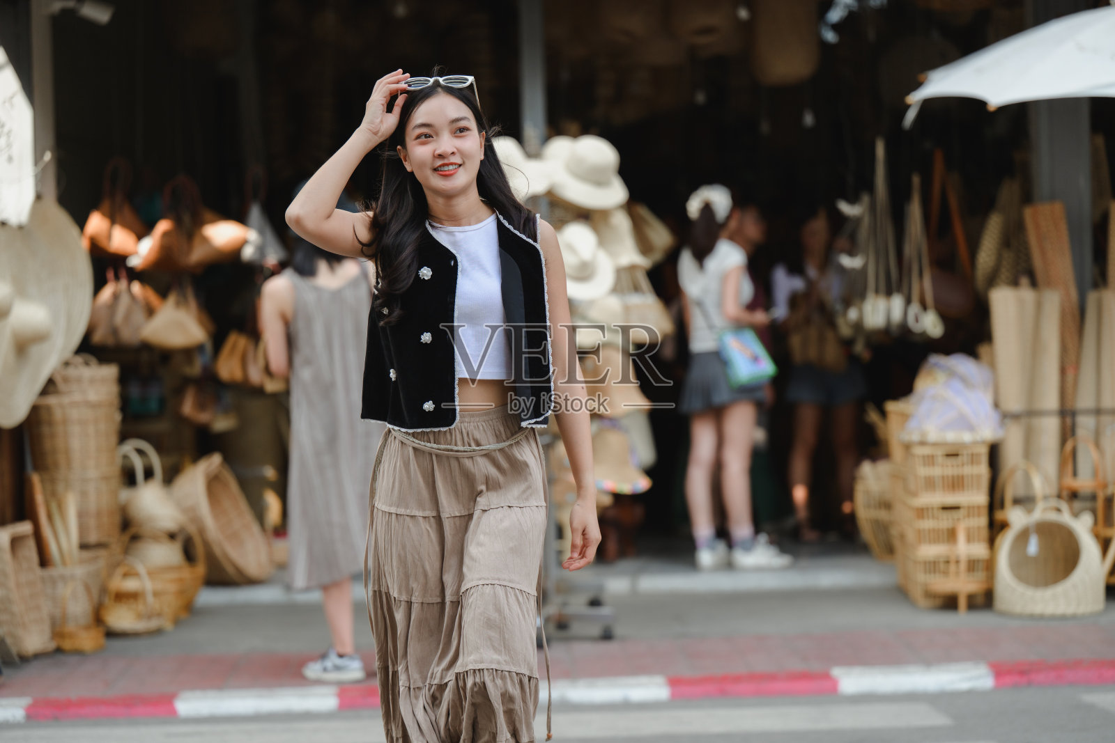 游客参观一家出售手工包和帽子的传统泰国商店照片摄影图片