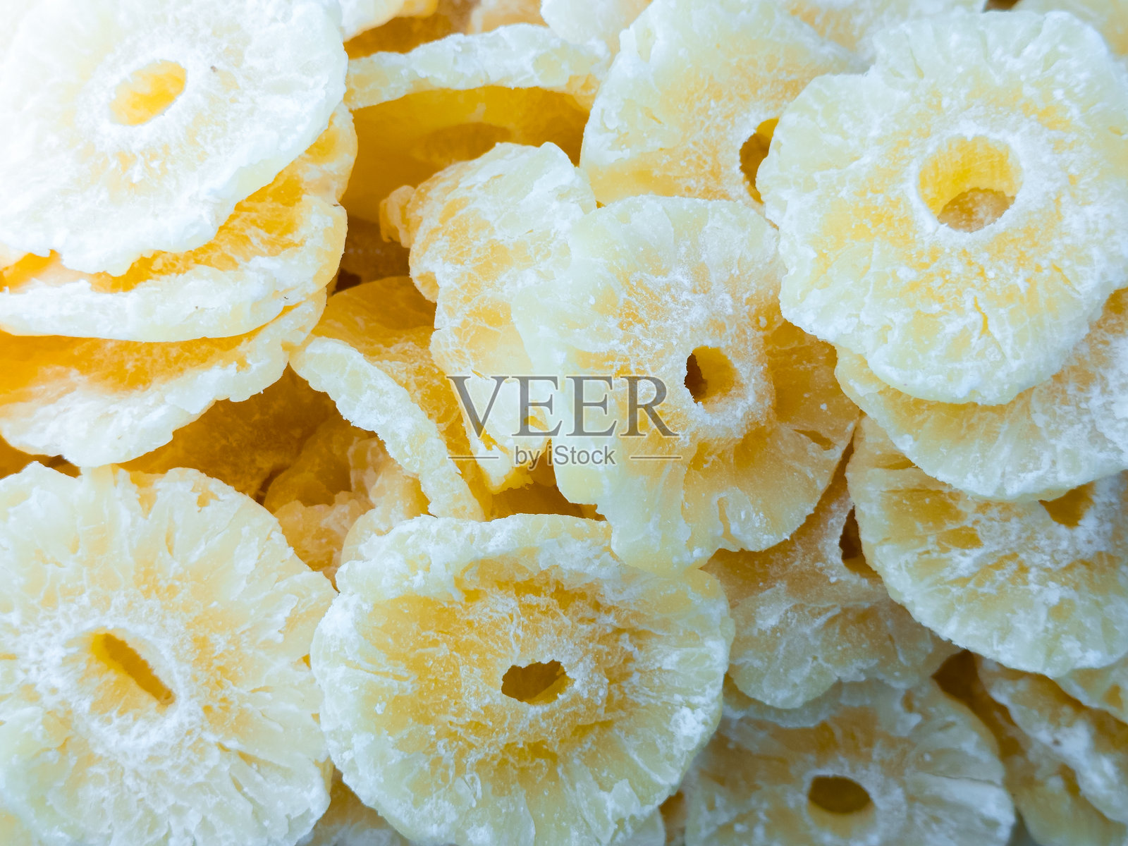 干燥菠萝片特写，表面有糖霜图案照片摄影图片