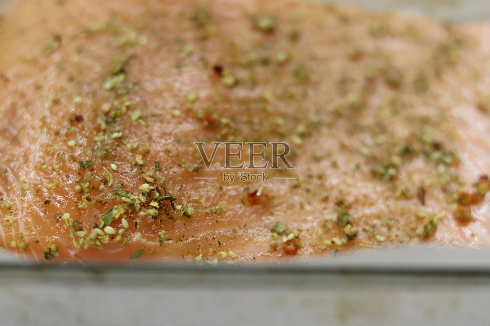 新鲜的三文鱼片用香草调味，准备在厨房中烘烤照片摄影图片