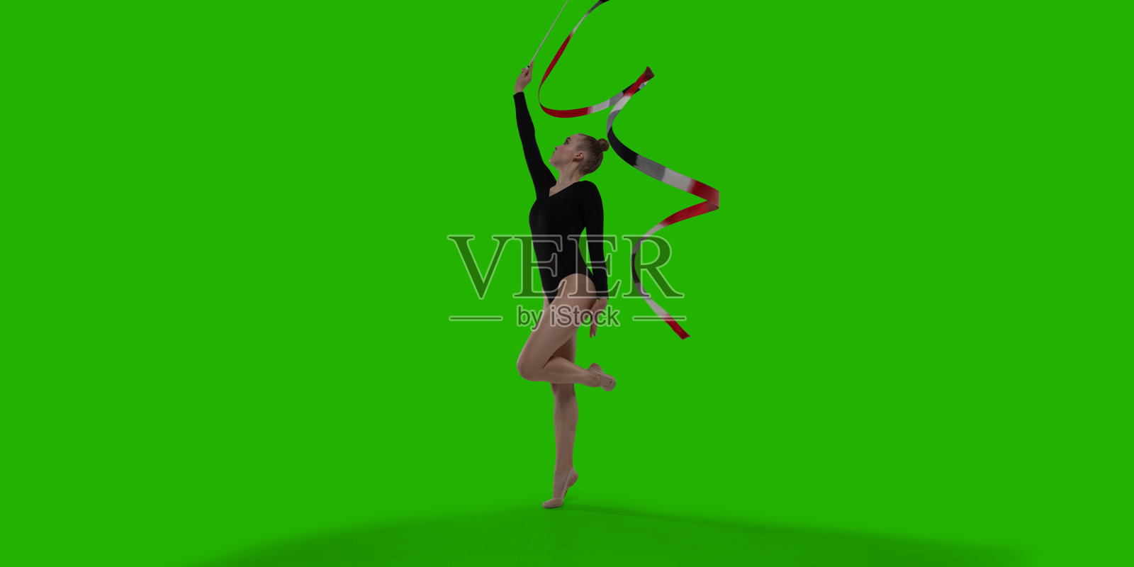 绿幕背景上的韵律体操女运动员。照片摄影图片