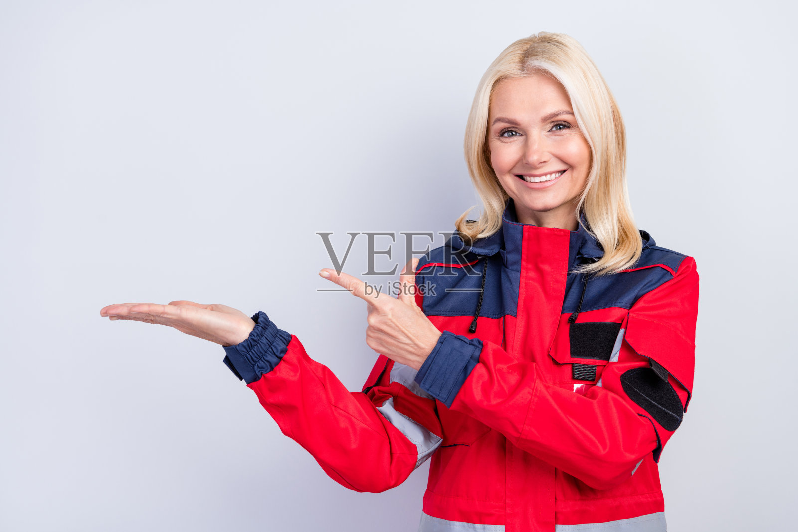 积极的人用手指指向空白空间，背景为灰色。照片摄影图片