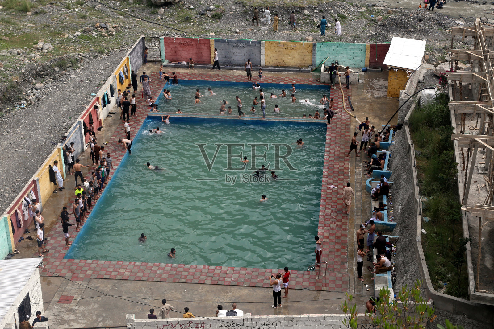 阿伯塔巴德，巴基斯坦：2025年6月29日，人们在阿伯塔巴德的Thandiani Top附近的山脉环绕下的天然泳池中游泳。照片摄影图片