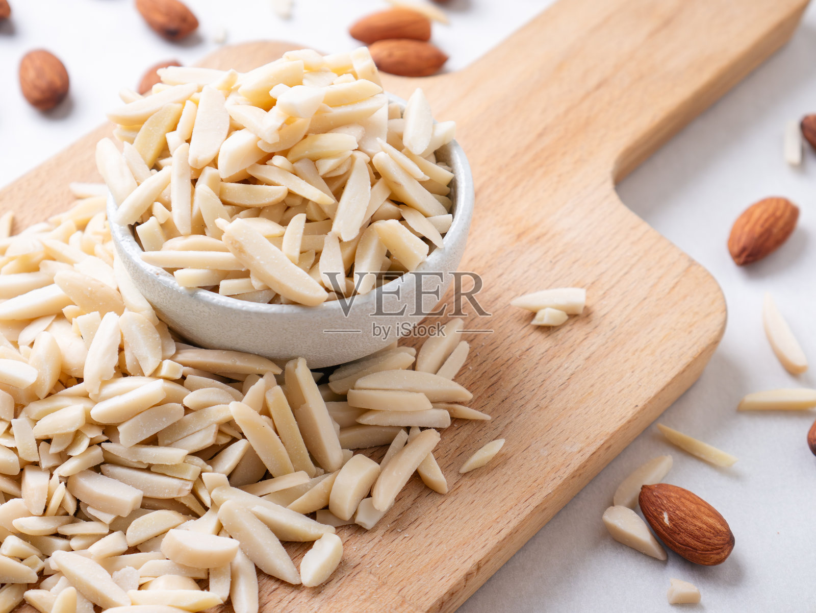 杏仁和白杏仁棒放在木板上，背景为白色。照片摄影图片