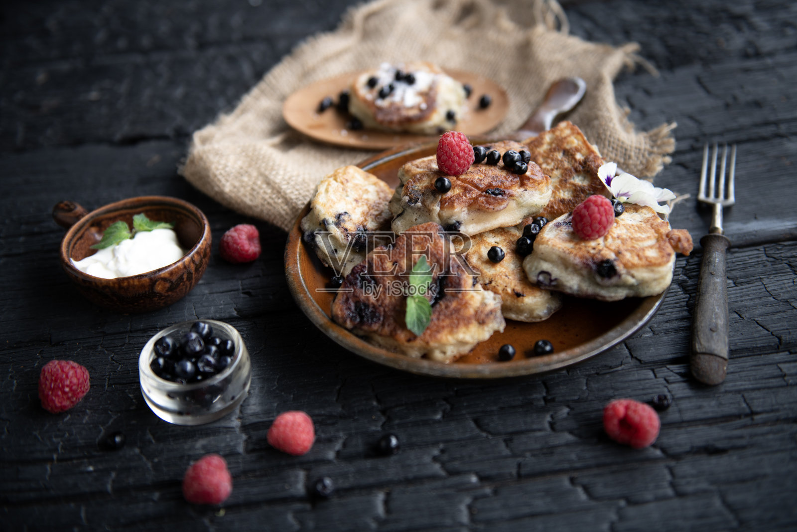 覆盆子和蓝莓的煎饼堆 – 黑暗情绪的美食摄影照片摄影图片