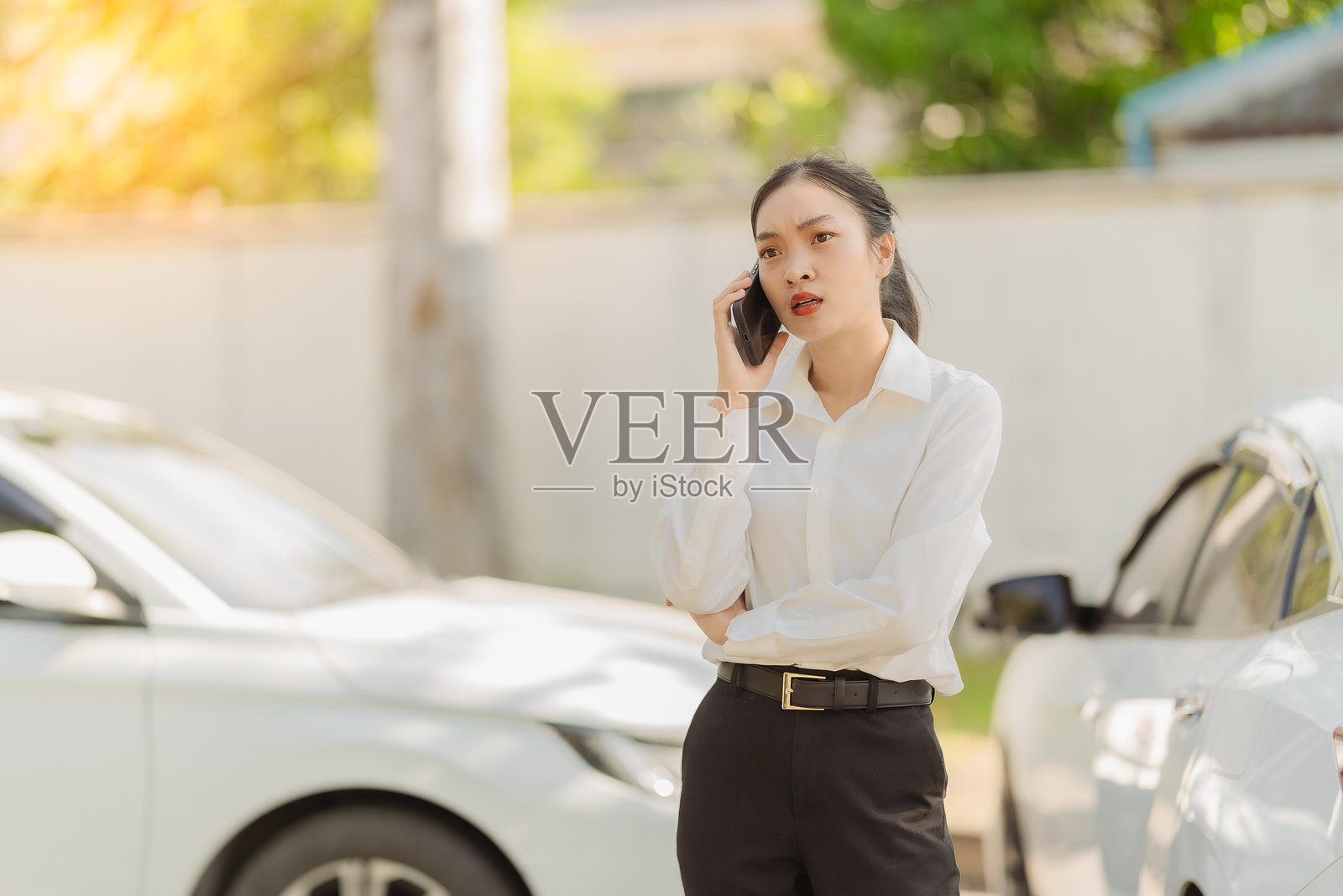 亚洲女性拨打保险代理人的电话寻求帮助，解决汽车问题，紧急汽车维修照片摄影图片