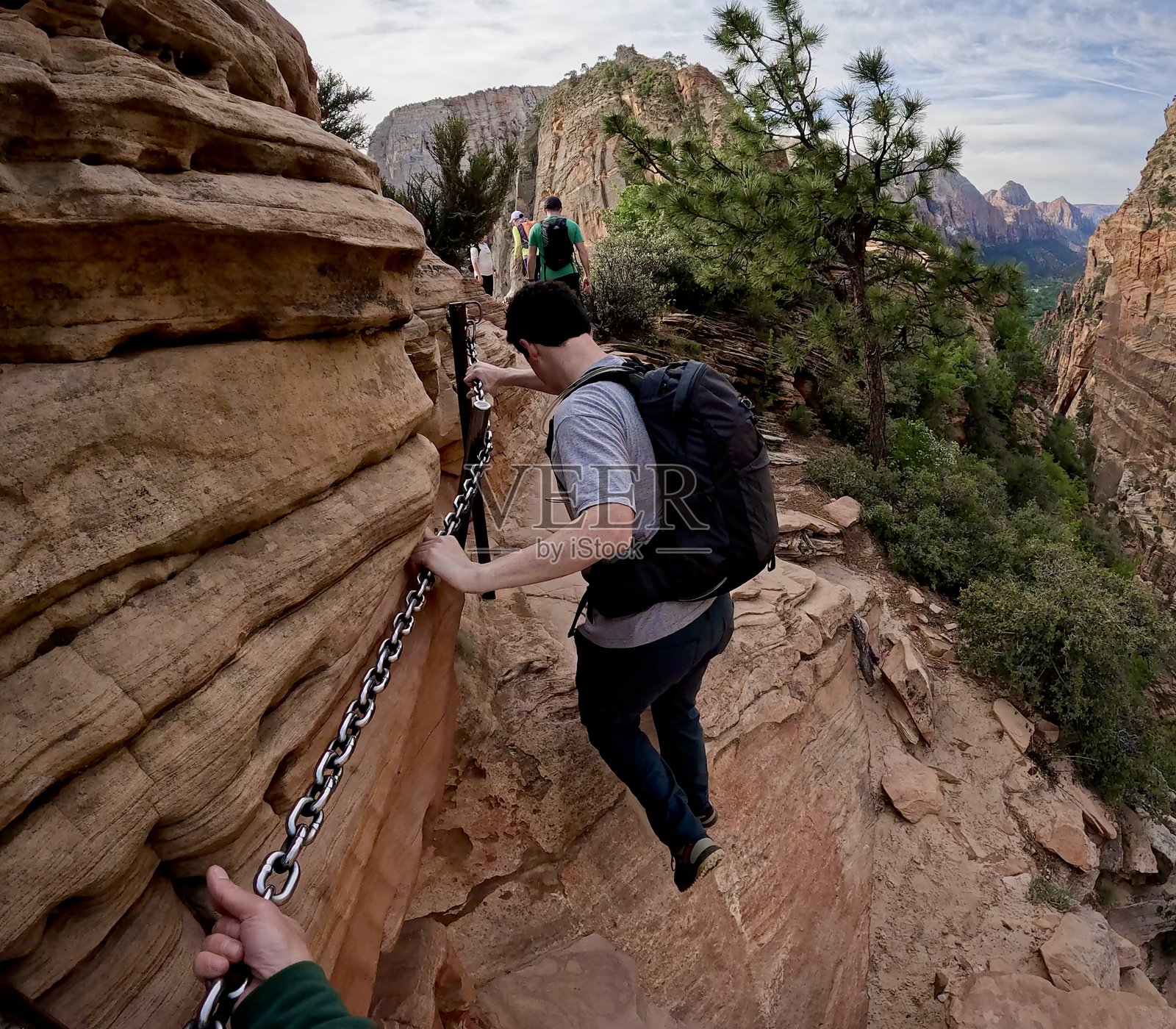 男子在天使降临岩的边缘使用链条照片摄影图片
