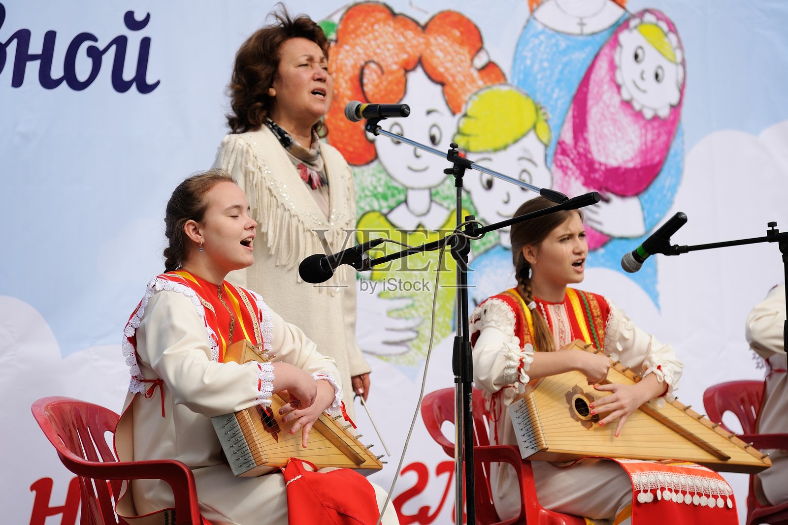 东正教家庭日。穿着俄罗斯服装的女孩们在演奏古斯利琴。照片摄影图片