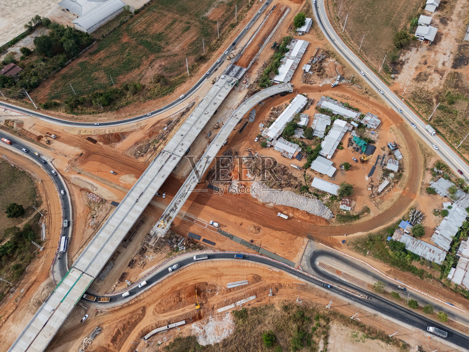 建筑工地在起重机工人、拖拉机和挖掘机的帮助下，正在为交叉口上方的混凝土桥梁施工前的准备工作。照片摄影图片