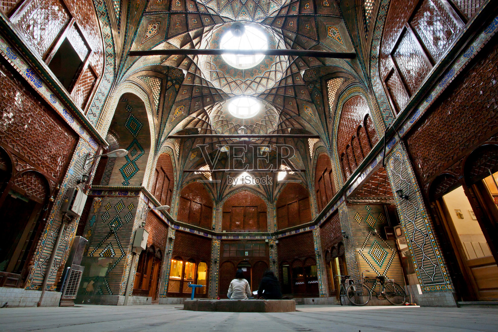 人们在设计独特的集市墙壁阴影下休息照片摄影图片