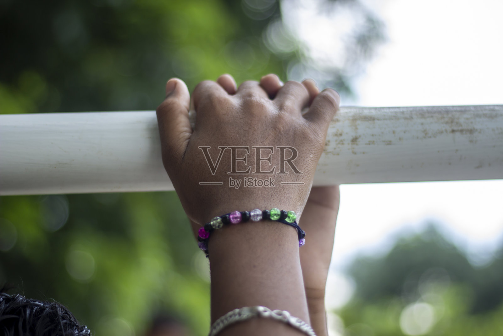 一个男人手里拿着一根管子，背景模糊不清。照片摄影图片