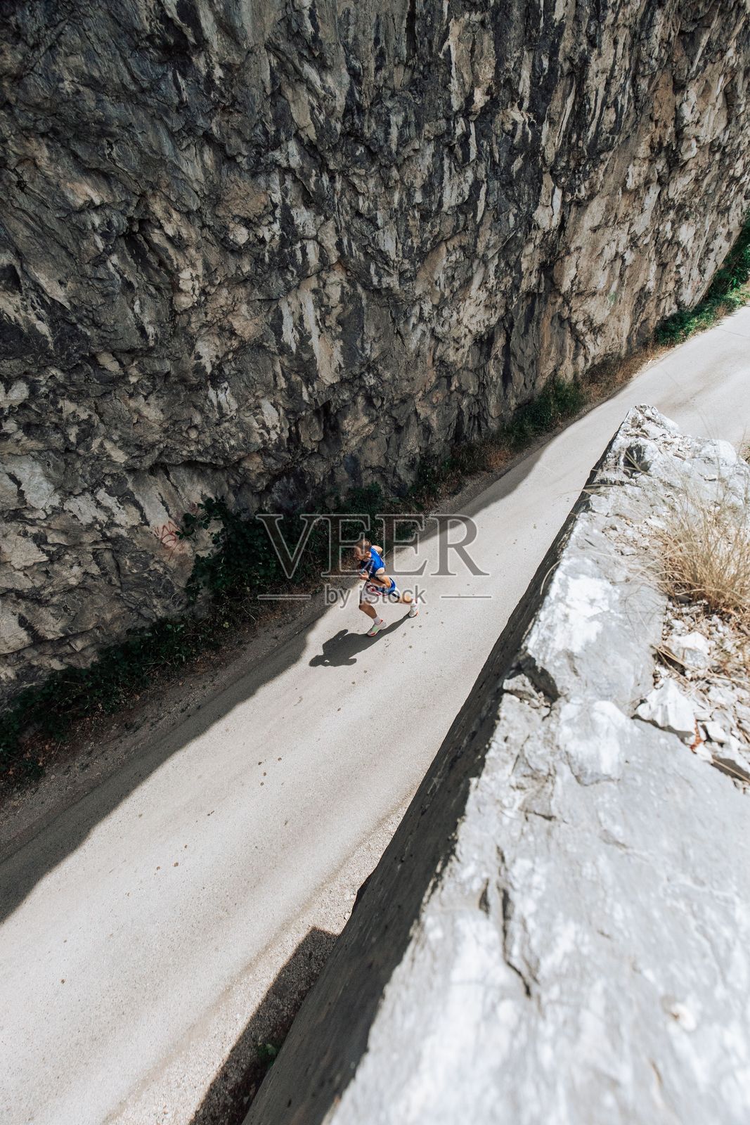 山路上奔跑者的鸟瞰图。照片摄影图片