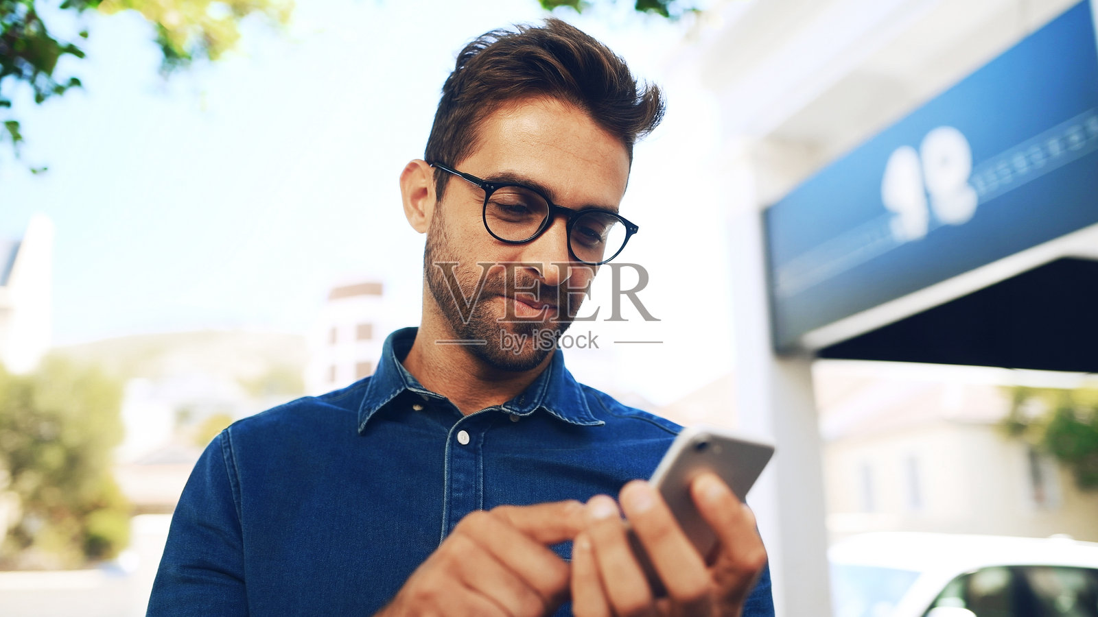 通勤，戴眼镜的员工在城市街道上用手机寻找方向。应用程序、地图和手机与商务人士在市中心人行道上进行沟通或通勤。照片摄影图片