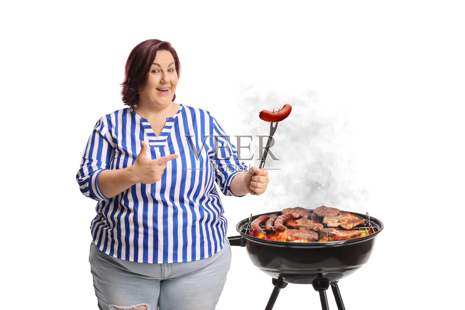 女人在烧烤架上烤肉，并指着一根香肠照片摄影图片