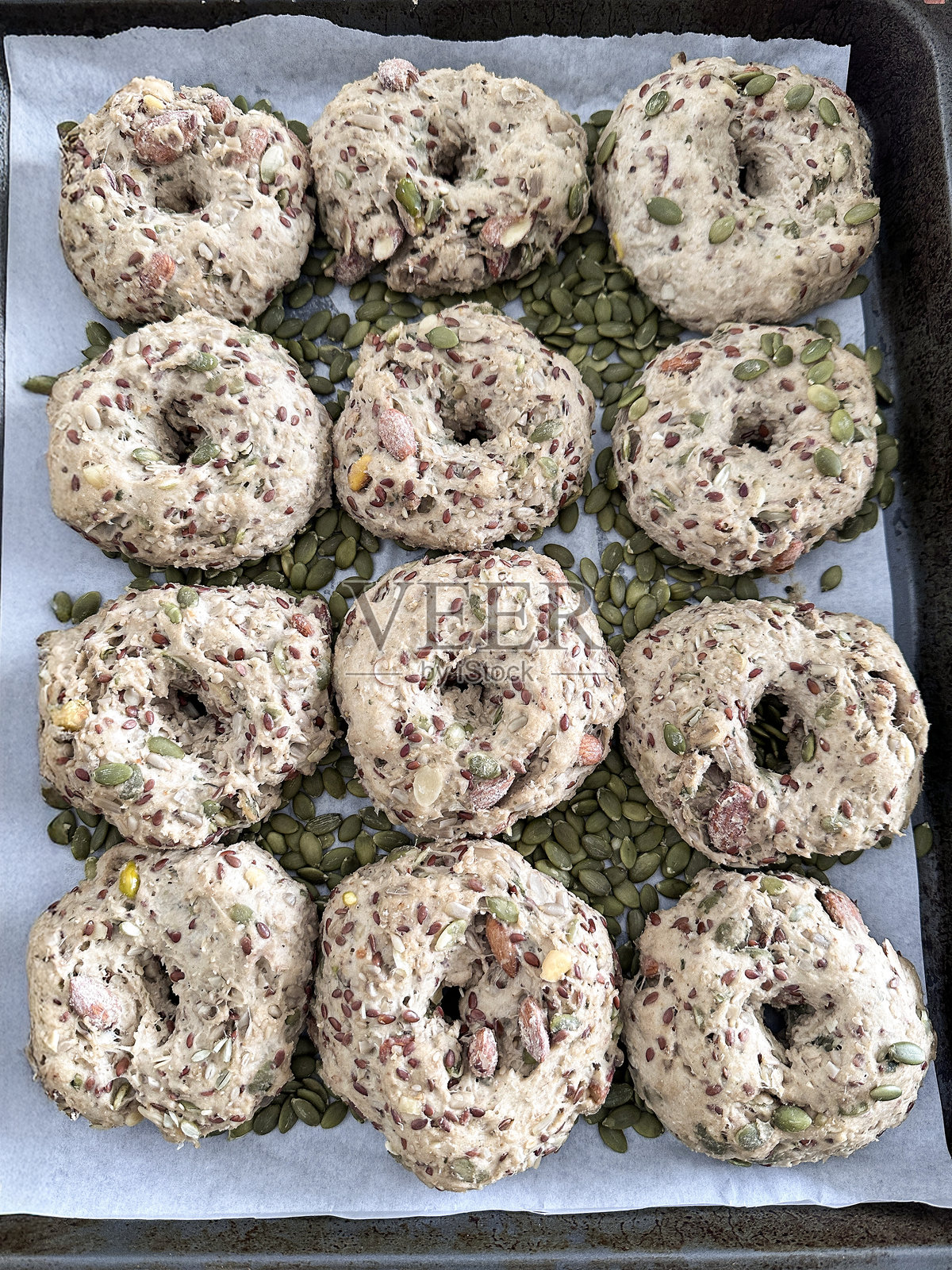 自制贝果面团的图像，使用南瓜和葵花籽，搭配全麦面粉，俯视新鲜家庭烘焙的场景照片摄影图片