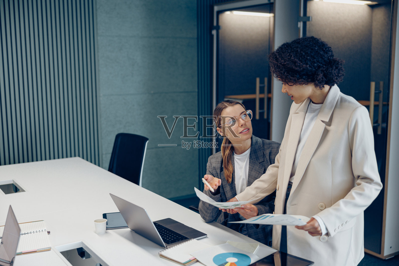 两位女性专业高管专家正在讨论财务会计文件，共同合作。照片摄影图片