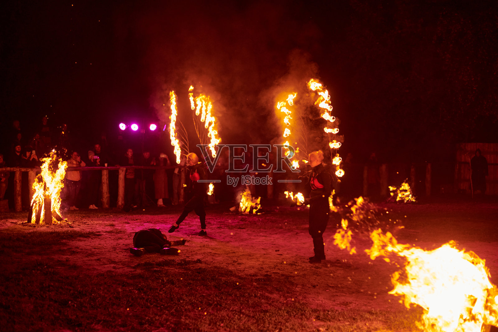 两位女性火焰表演艺术家在黑暗背景下展现火焰翅膀照片摄影图片