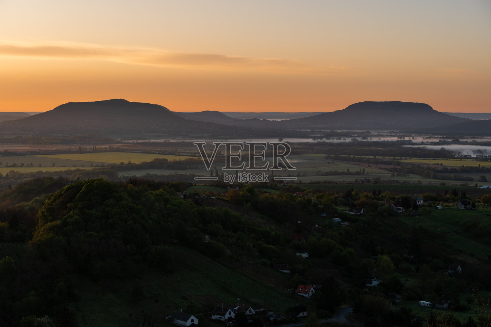 巴拉顿高地上雾气弥漫的乡村山谷景观中的金色日出照片摄影图片