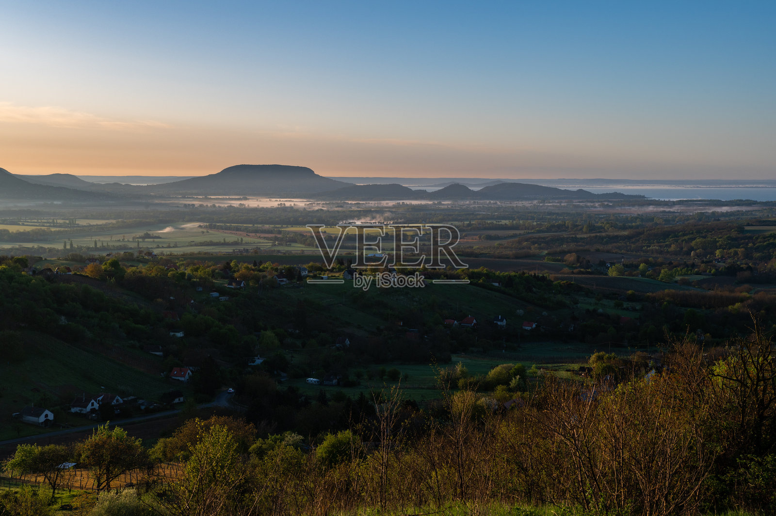 巴拉顿高地的乡村山谷和远处山丘上的晨光照片摄影图片