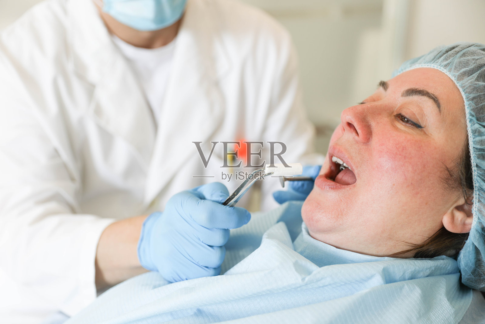 牙医为女性患者进行口腔治疗照片摄影图片