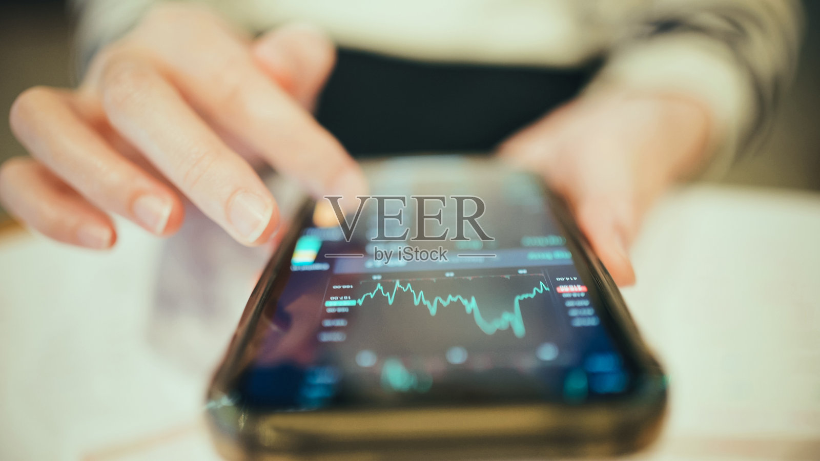 年轻女性在户外使用智能手机获取财务信息和投资动态，分析2026年城市移动应用中的投资趋势。照片摄影图片