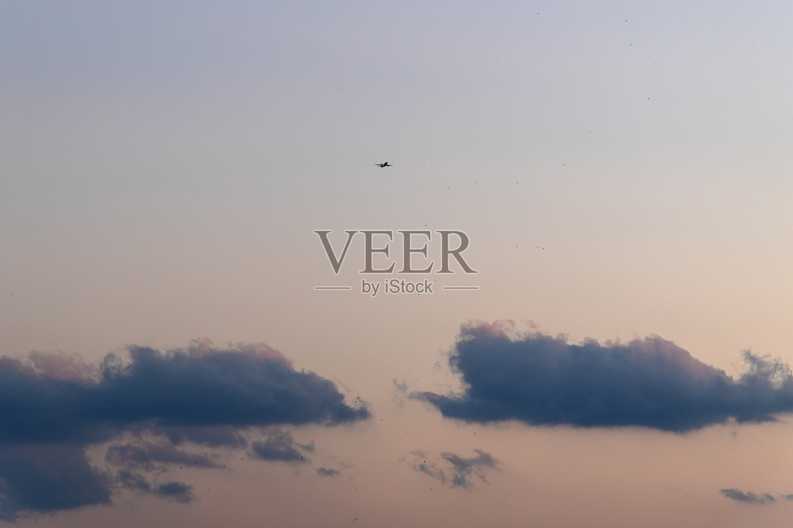 飞机在日落的天空中飞行照片摄影图片