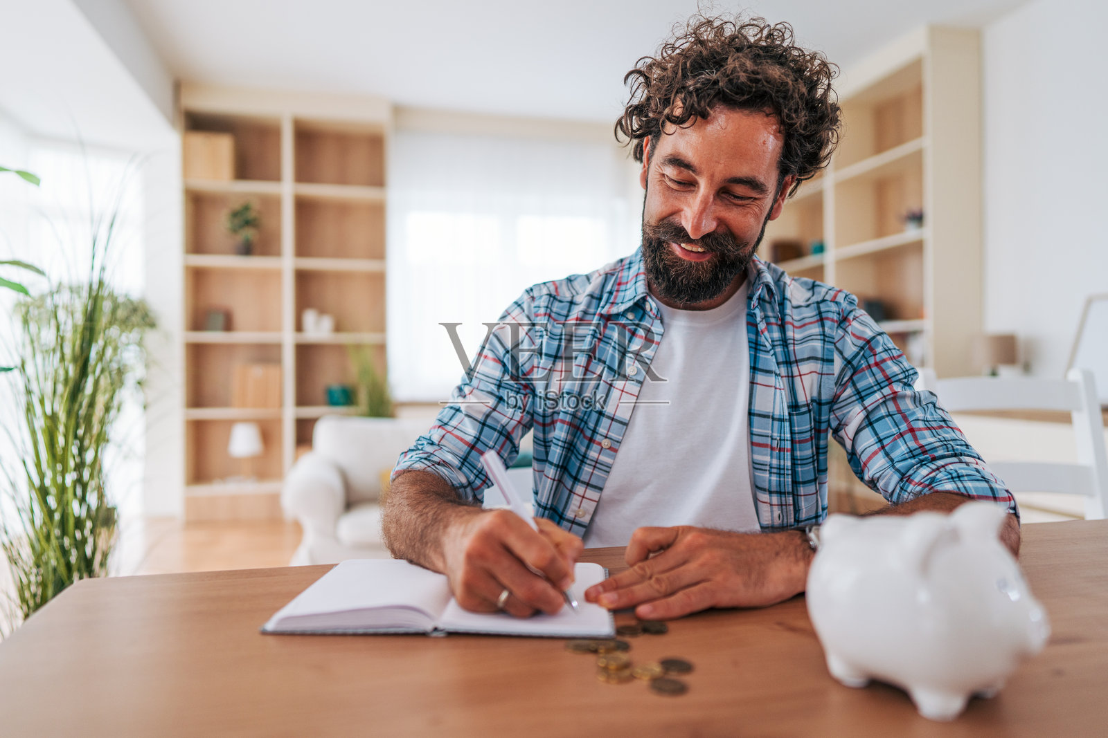 男子管理家庭财务并用储蓄罐计算存款照片摄影图片