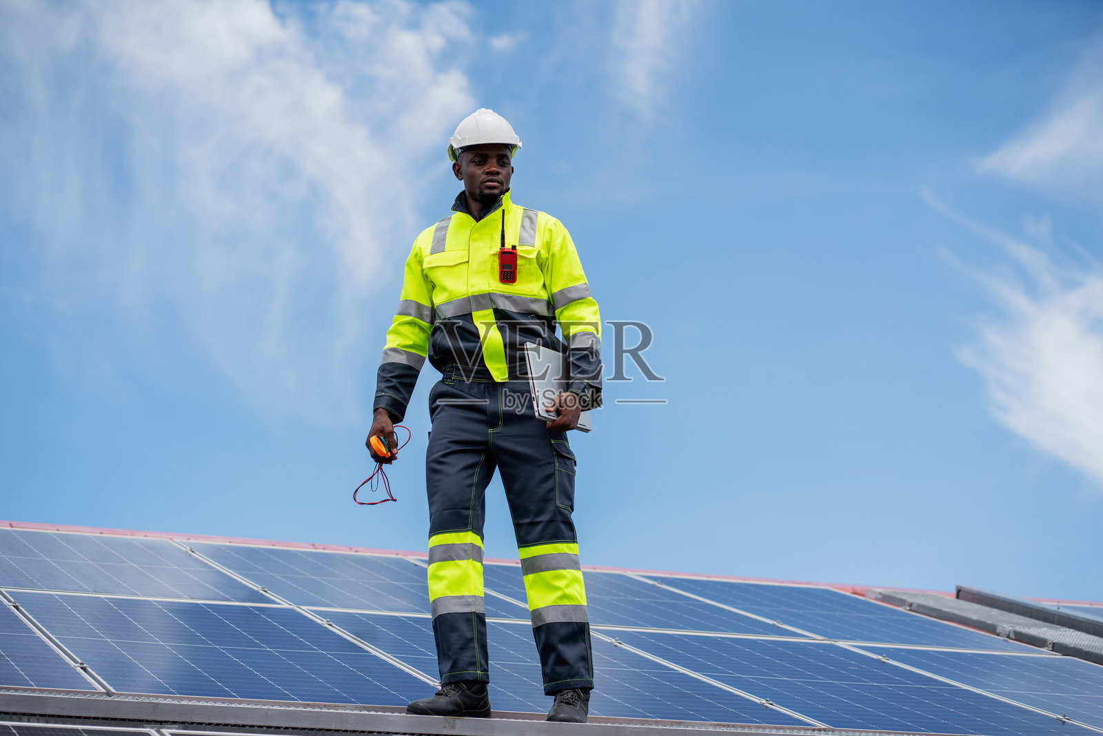服务工程师在屋顶检查太阳能电池以进行维护，查看是否有损坏的部件。工程师正在安装太阳能板。清洁能源概念。照片摄影图片