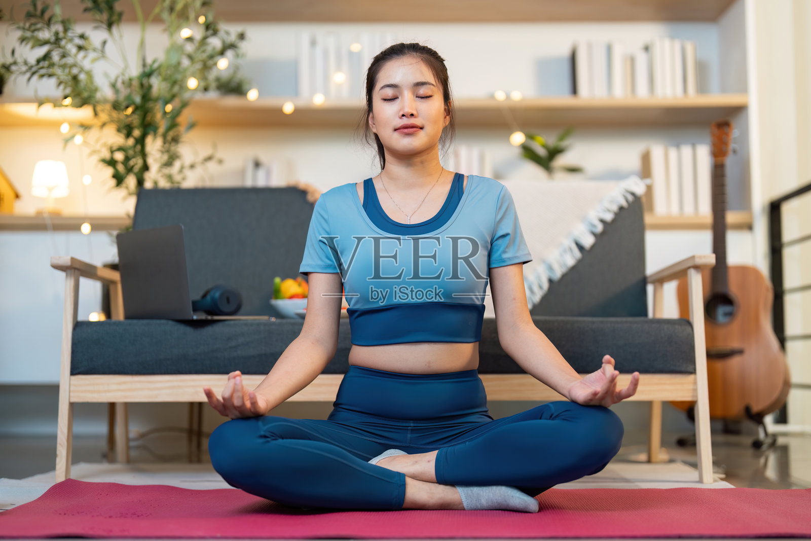 正念。年轻女性在舒适的家居环境中冥想。照片摄影图片