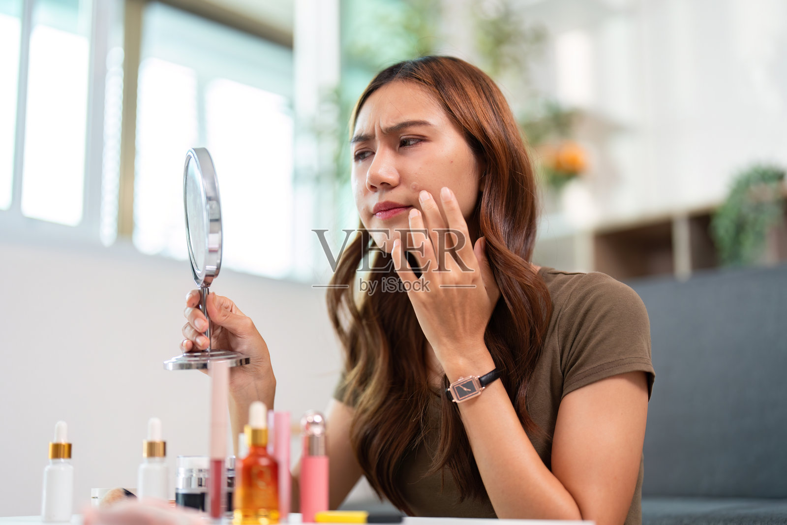 护肤重点。女性在镜子前检查自己的皮肤以寻找有效的治疗方法。照片摄影图片