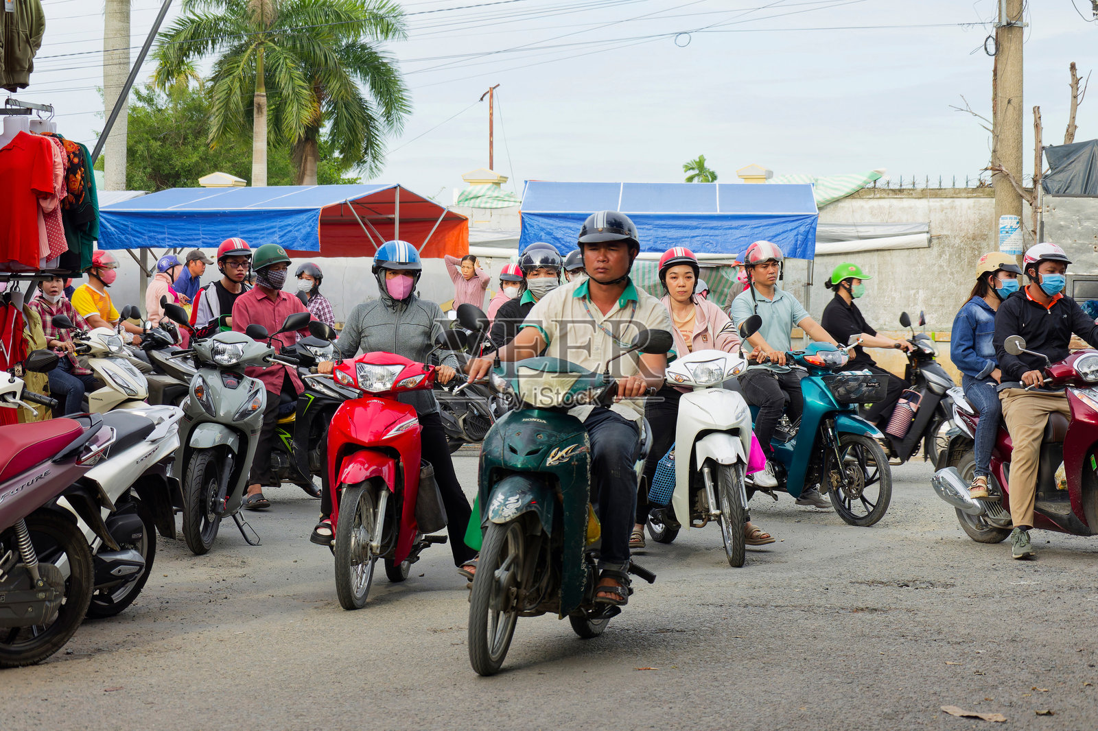 越南工业工人在摩托车上忙碌的下午通勤,离开Hoa Phu工业园,展示了日常生活和经济活动。照片摄影图片