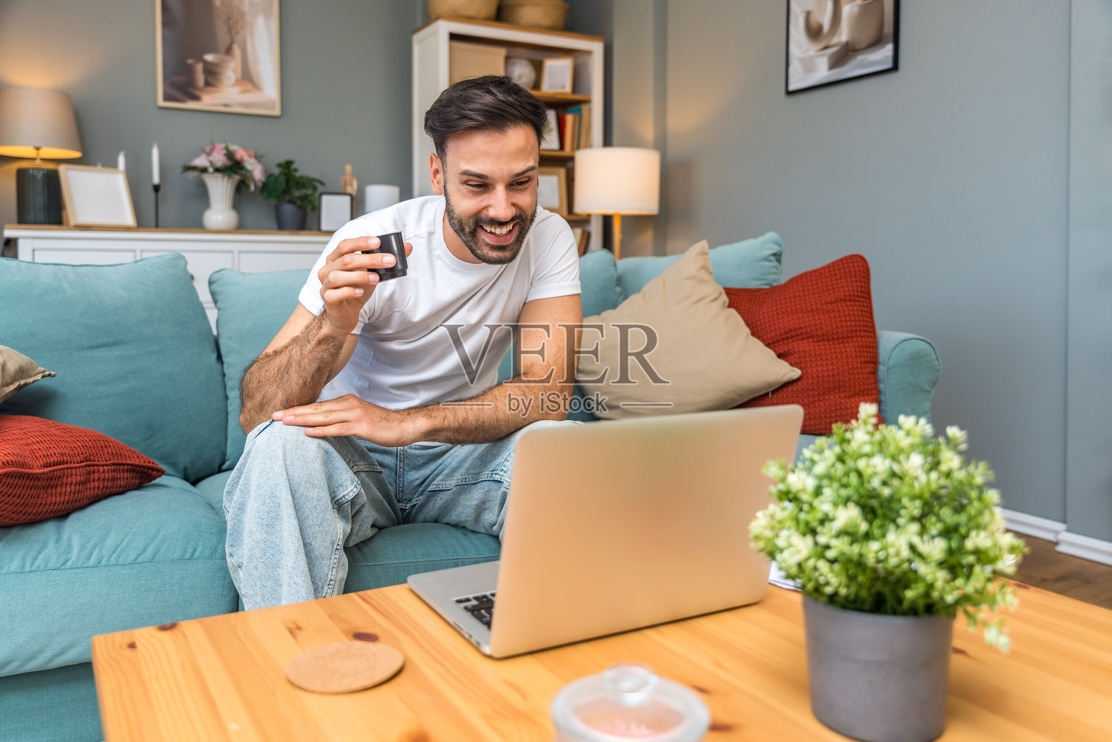 年轻的商业人士，小型创业公司的老板，在家工作，查看图表和笔记本电脑上的财务数据。创新的年轻自由职业男性正在计算新产品策略的成本和开支。照片摄影图片