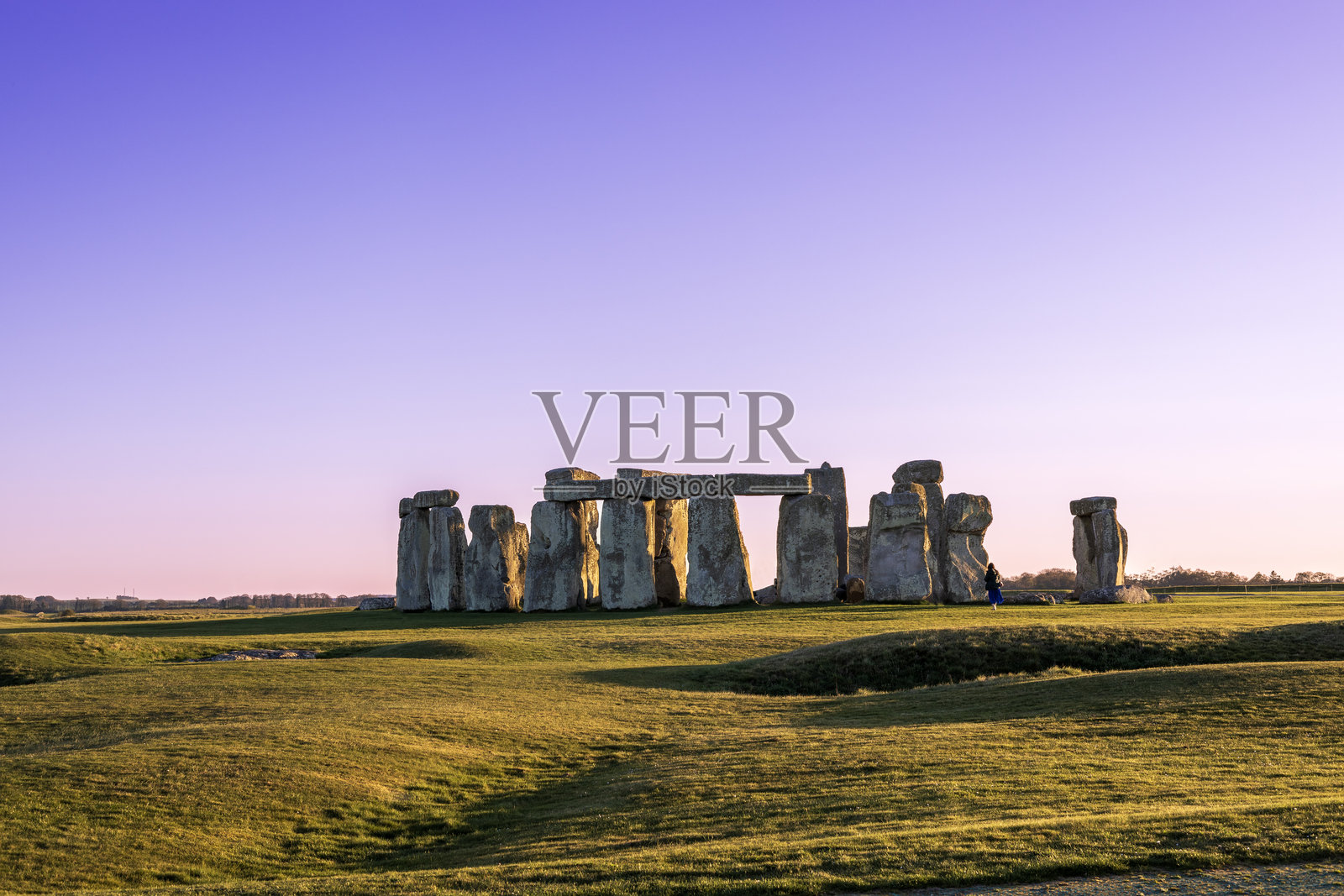 在英国索尔兹伯里，粉色和紫色日落时分的巨石阵景观。照片摄影图片