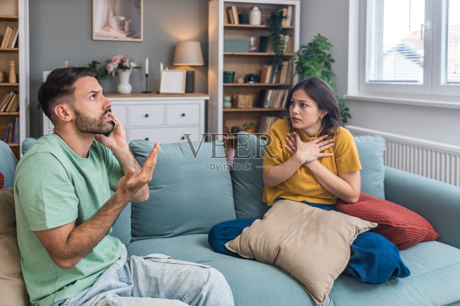 年轻情侣拨打警察电话报告家庭暴力。男女拨打911报告楼上公寓传来的巨大噪音，争吵和尖叫声。邻居在家中发生争斗。照片摄影图片