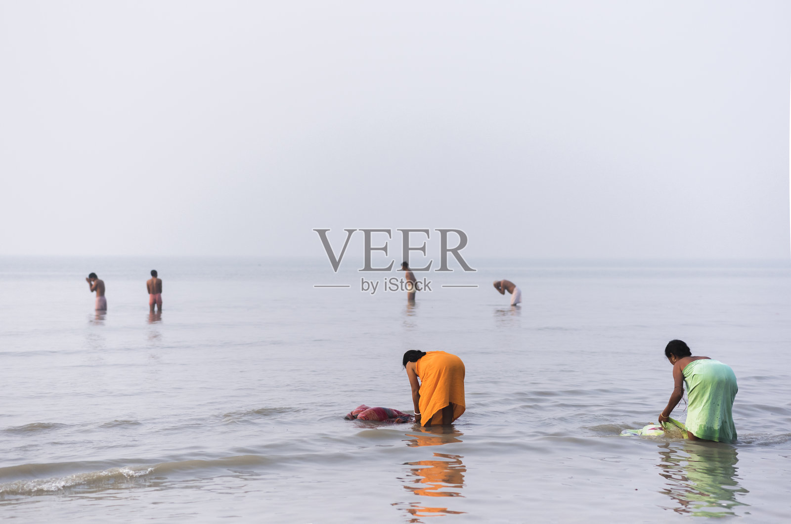 信徒们在恒河中进行圣水沐浴照片摄影图片