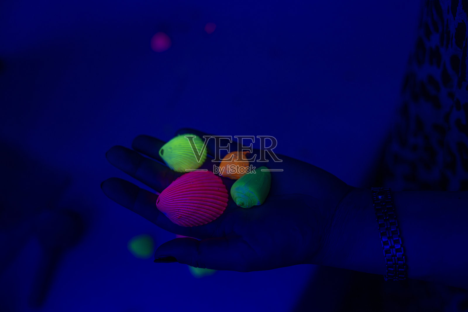 在昏暗的房间里，创意女孩在画布上作画，周围被霓虹灯照亮。照片摄影图片