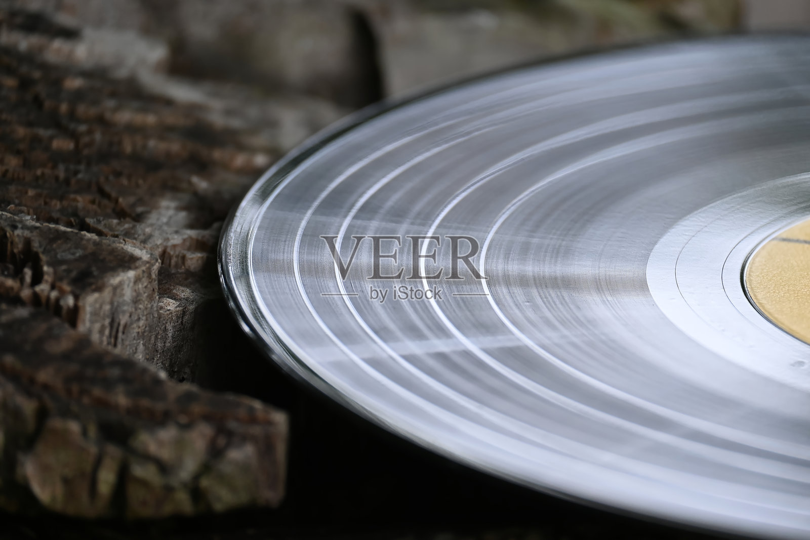 一张复古黑胶唱片静静地放在风化的木头上，唤起怀旧的感觉。照片摄影图片