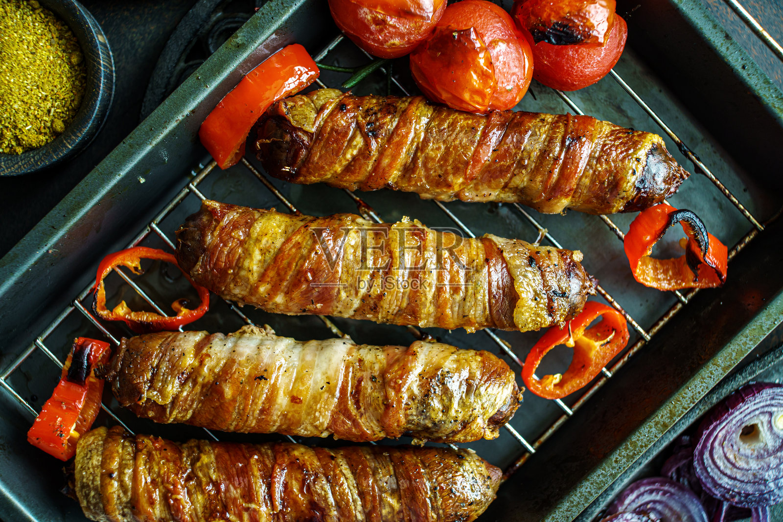 烤盘上的烤培根、西红柿和洋葱香肠照片摄影图片