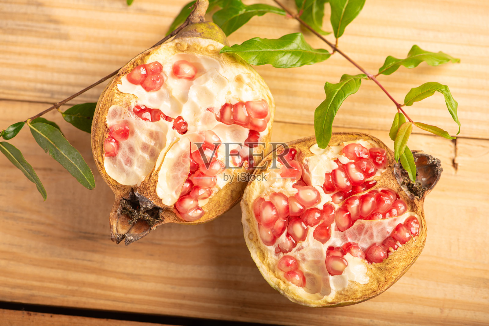 石榴，一个美丽的石榴在质朴的木头上，选择性的聚焦。照片摄影图片