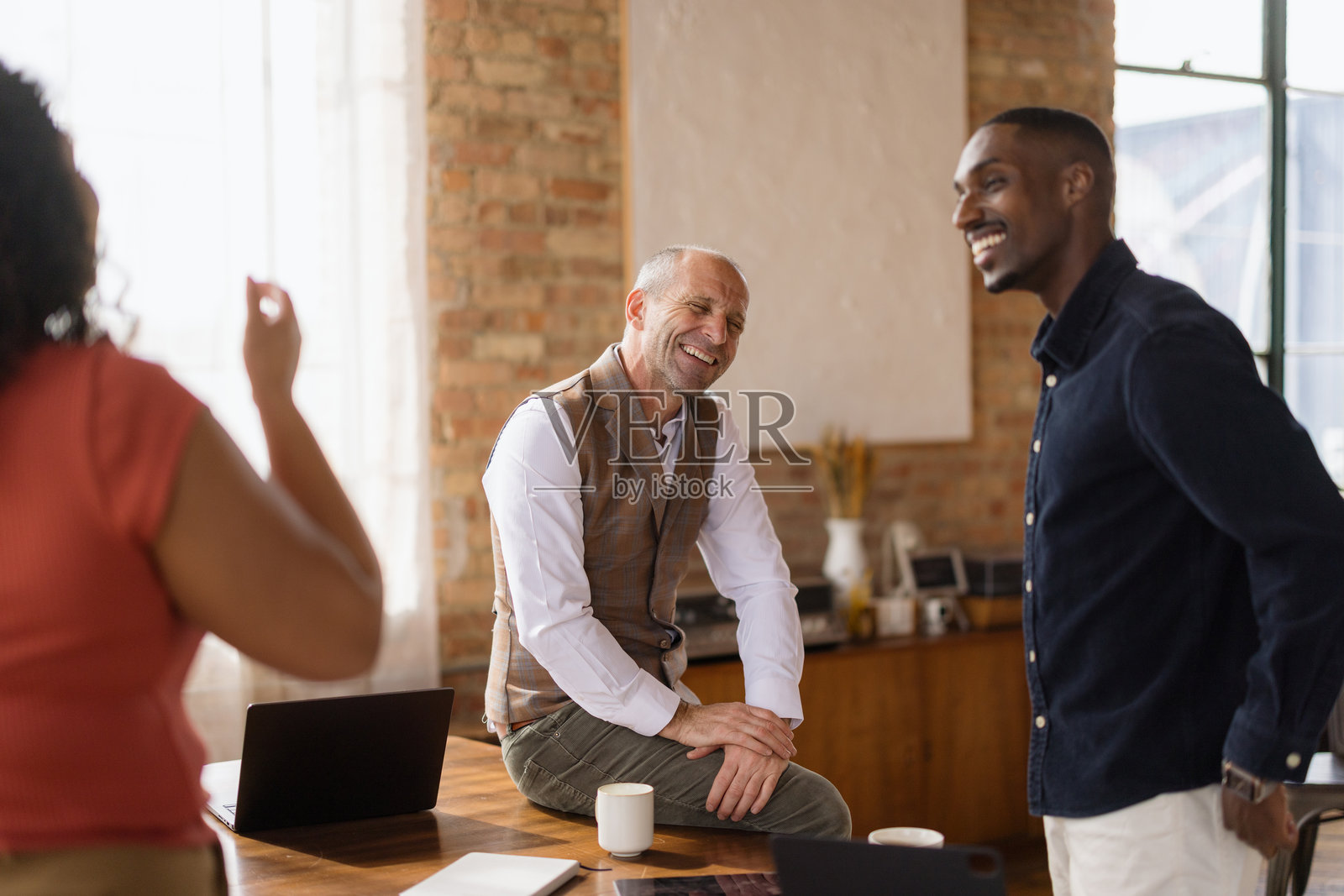 创意商业团队在非正式办公室会议中欢笑照片摄影图片