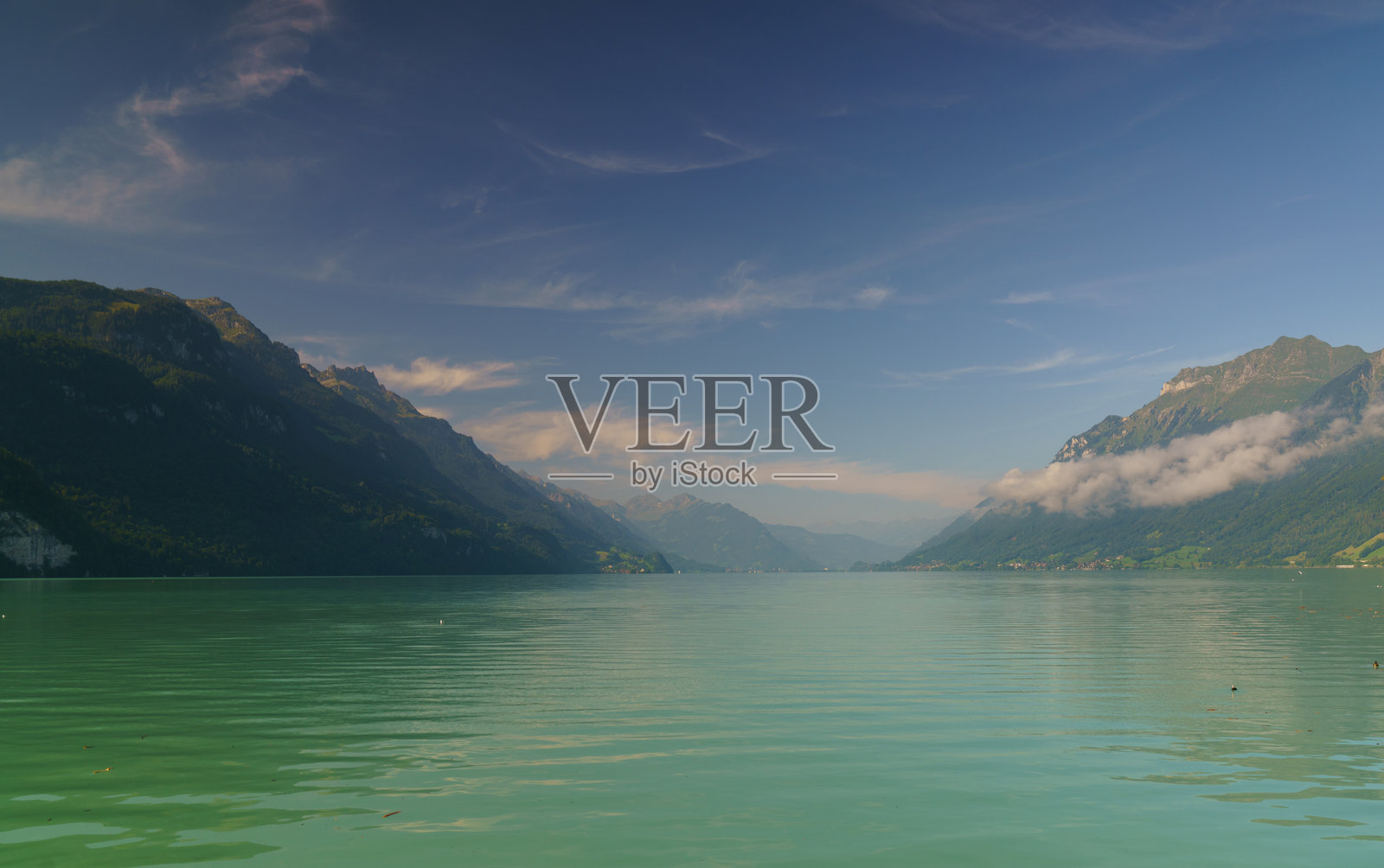 布里恩茨湖的宁静景色，湖面上漂浮着小船，背景是瑞士阿尔卑斯山。照片摄影图片