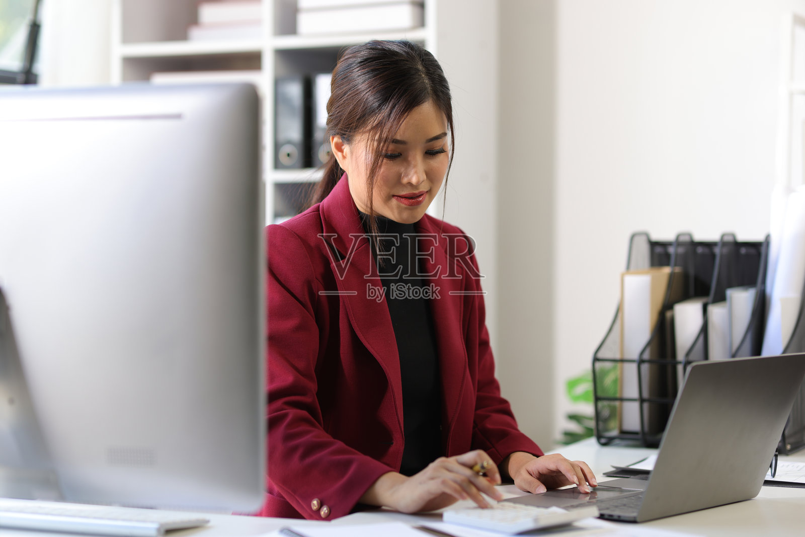 女商人在办公室处理会计文件并分析商业财务报告中的财务数据。照片摄影图片