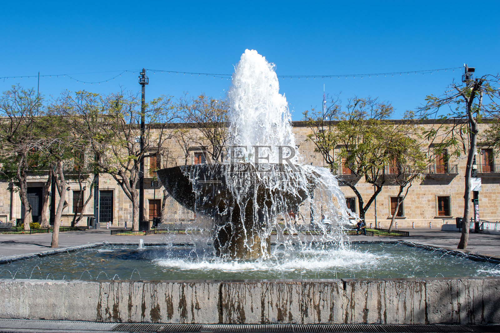 瓜达拉哈拉公共广场的石制喷泉与殖民建筑照片摄影图片