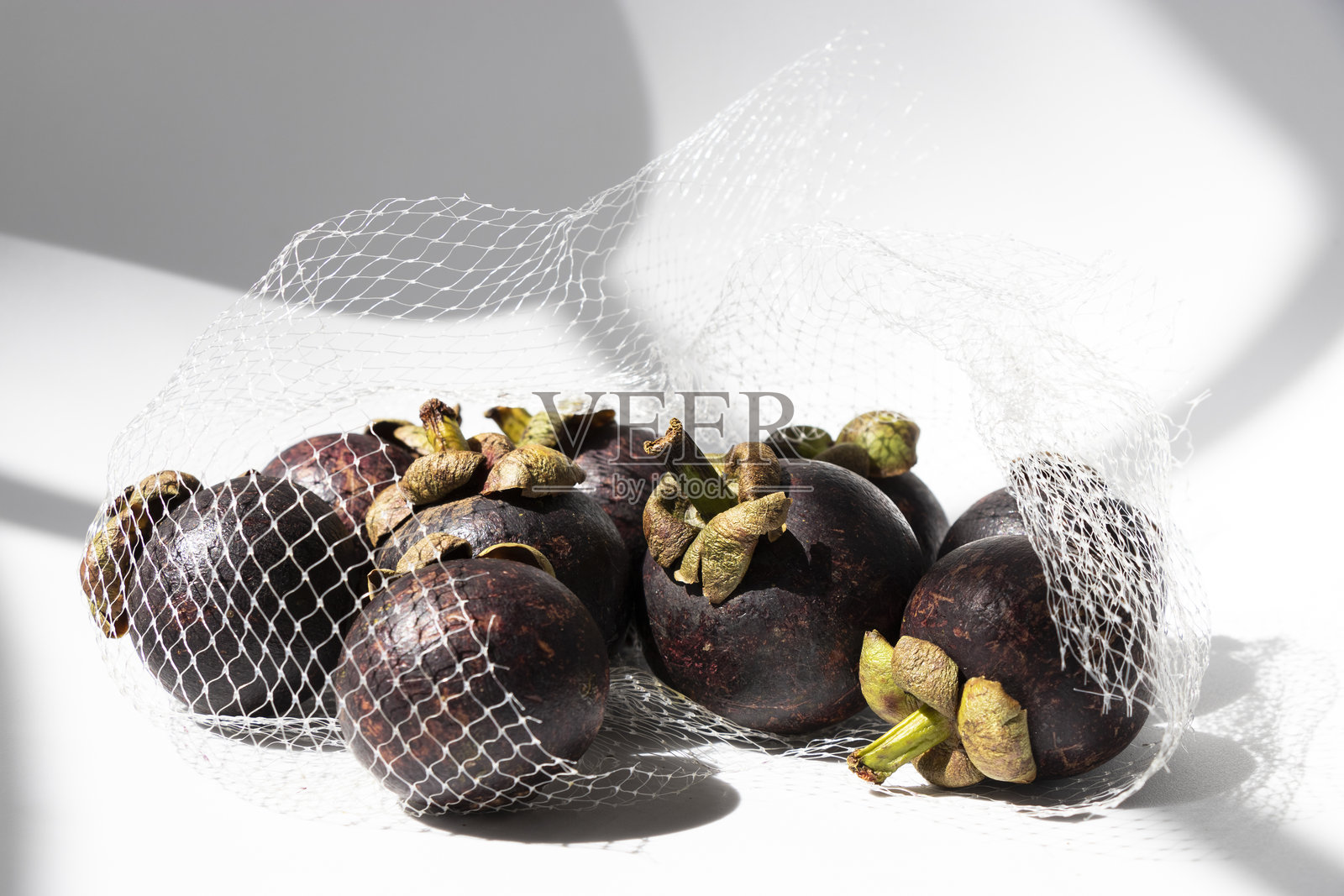 白色表面上的网状包装山竹照片摄影图片