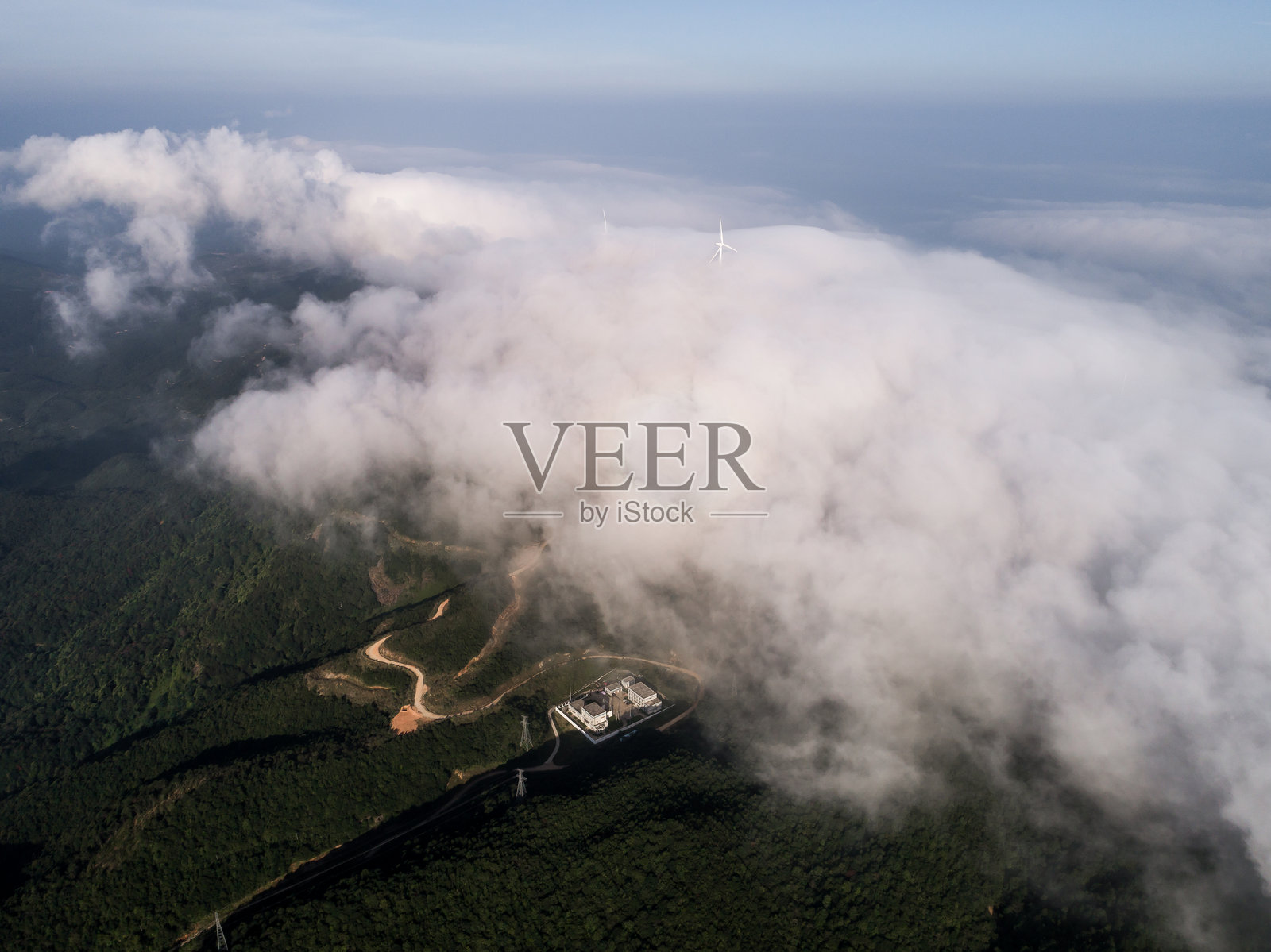 风力发电厂的航拍，山上的风车在云海中。蓝天和白云。照片摄影图片