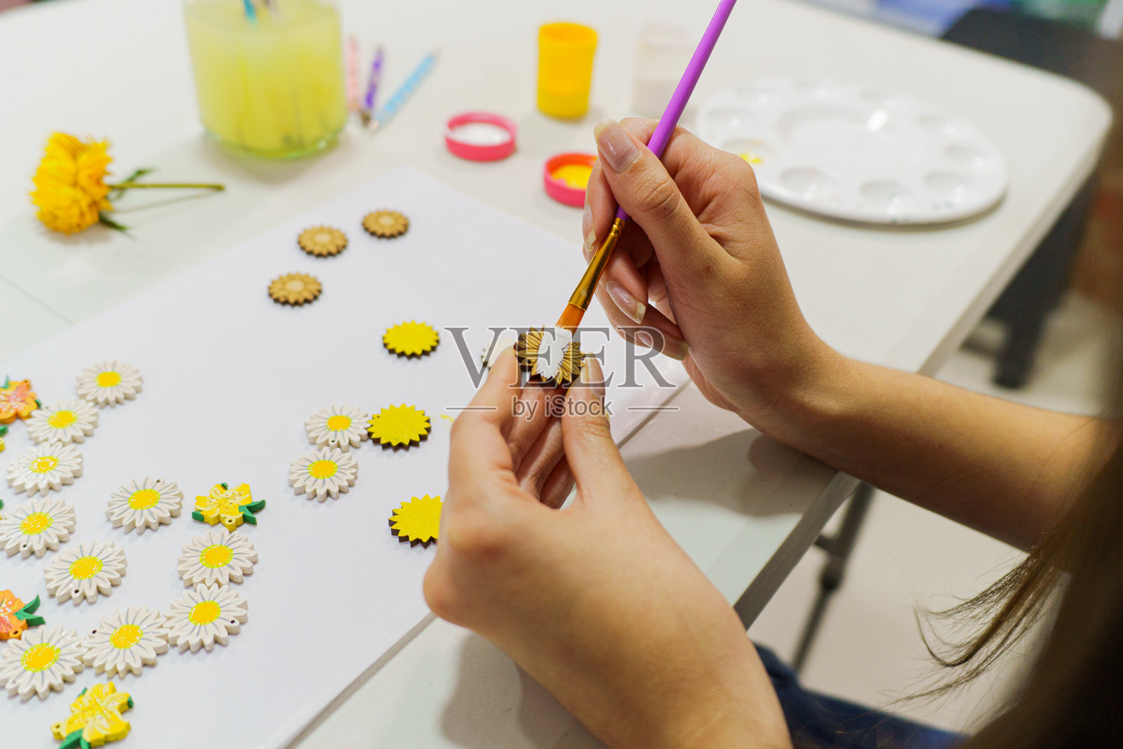 艺术家用白色丙烯颜料绘制木质雏菊装饰品照片摄影图片