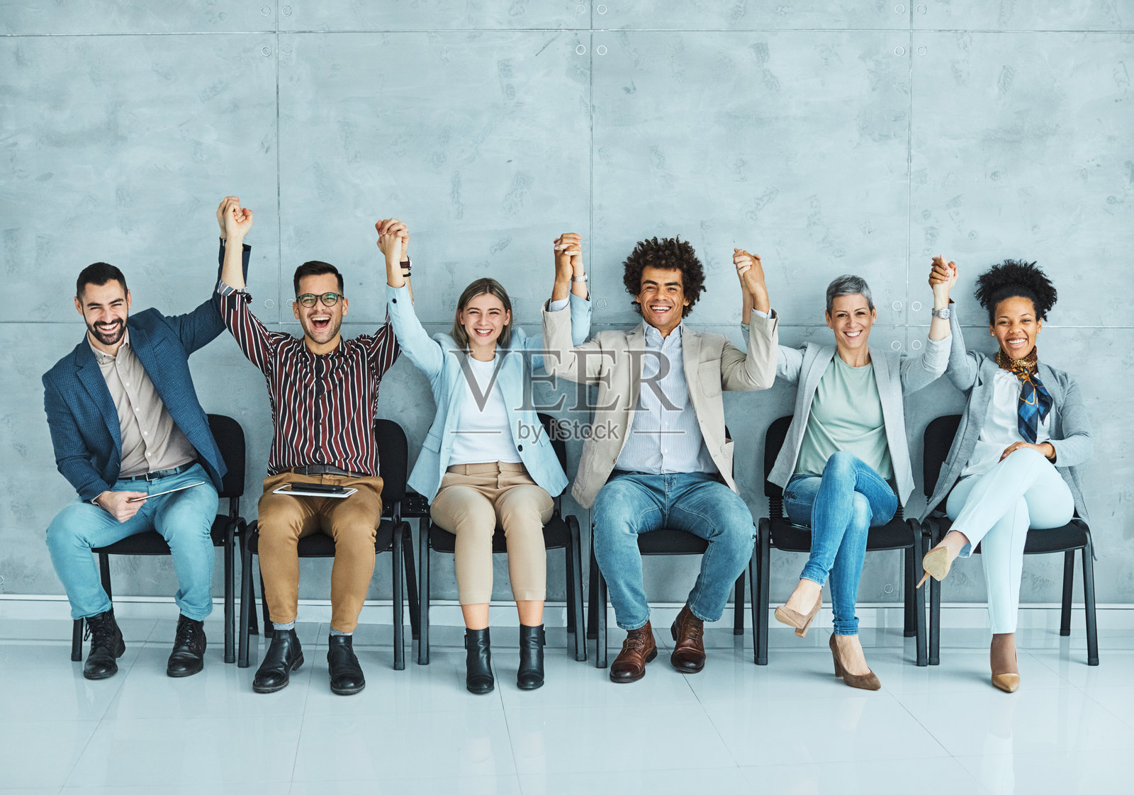 男士坐在商务椅上等待女性商务候选人面试，办公室内的年轻商务人士双手合十。照片摄影图片