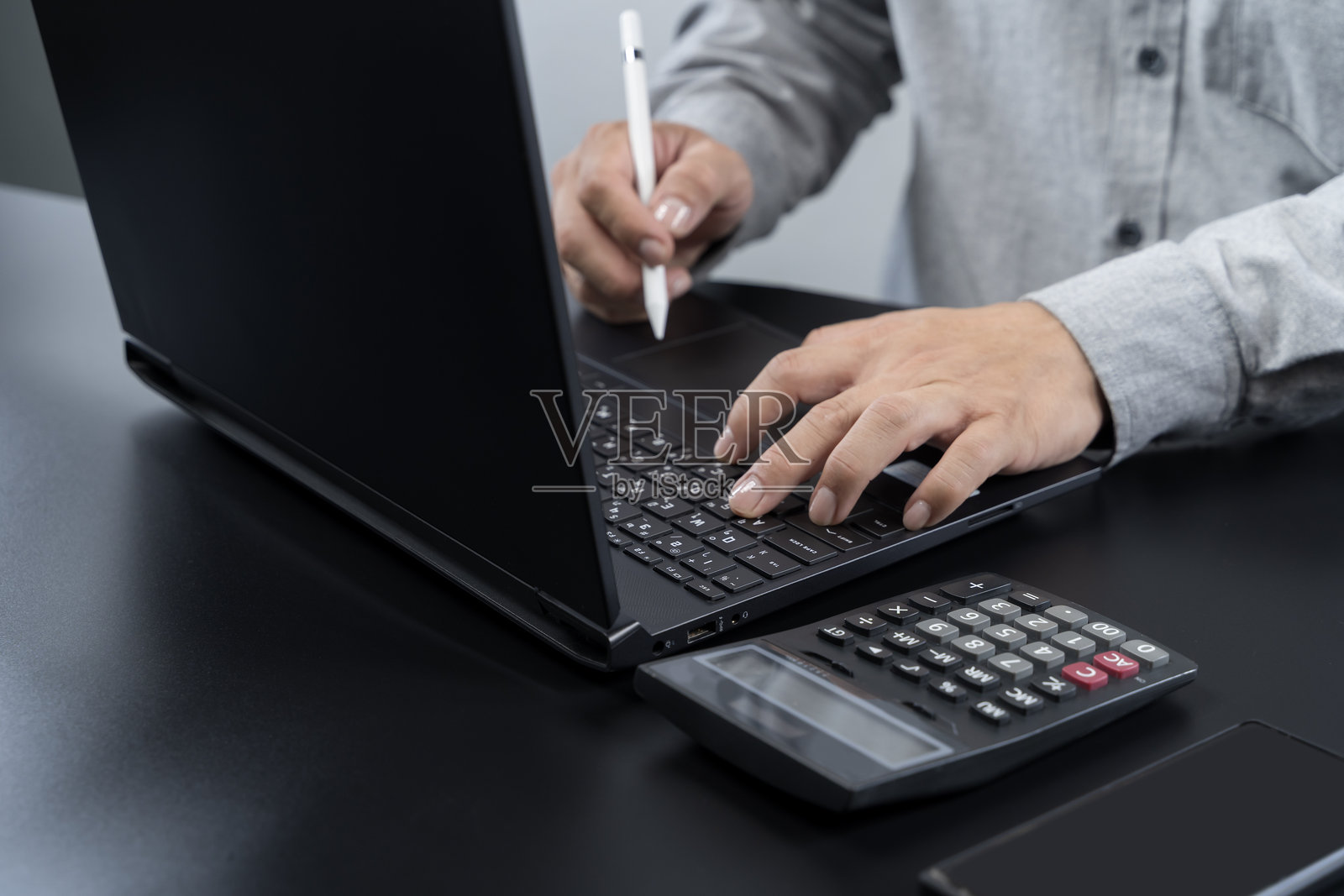 商人使用笔记本电脑、计算器和数字笔，进行财务、会计和规划的概念照片摄影图片