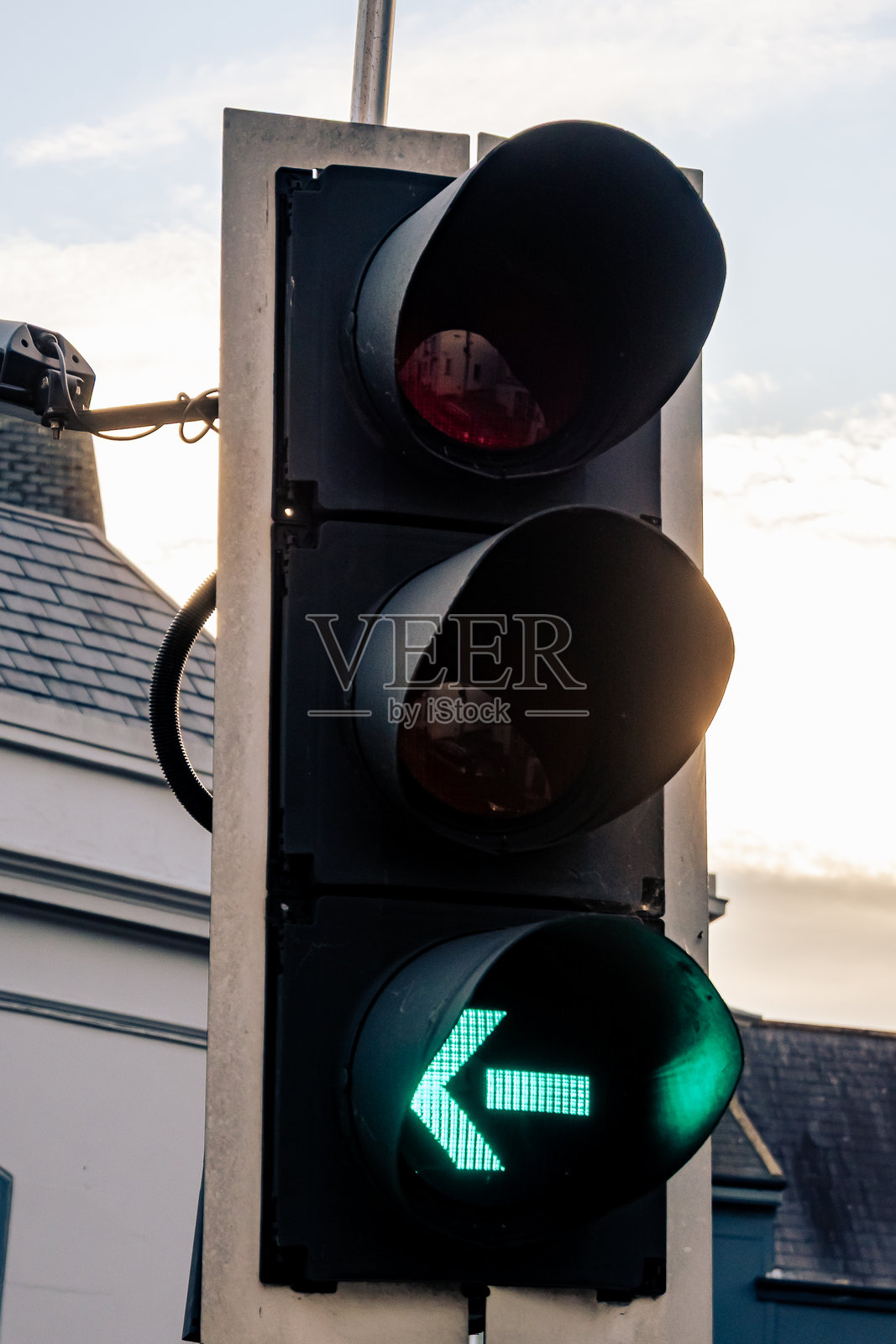 交通信号灯上的绿色左转箭头表示车辆安全行驶的方向。照片摄影图片