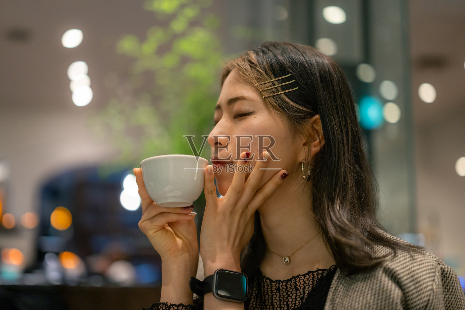 年轻女性自由职业者在咖啡馆喝茶 - 冥想照片摄影图片